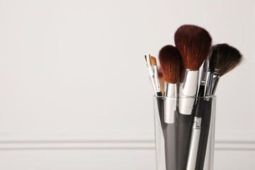 Set of professional makeup brushes on white background. Space for text