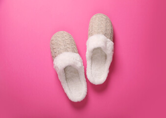 Pair of beautiful soft slippers on pink background, top view