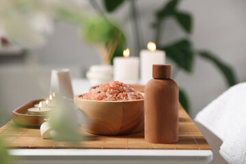 Cosmetic products and candles on table in spa salon, space for text