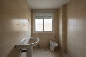 Fototapeta na wymiar An empty unfinished bathroom with dirty tiles and uninstalled sanitary ware