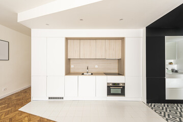 Front of a nice contemporary open plan kitchen with handleless cabinets, built in appliances and mixed tile flooring
