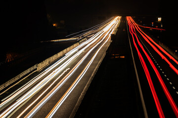 Cars light trails at night in curve asphalt road. Long exposure showing the movement of traffic...