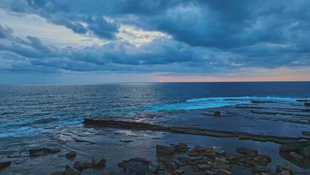Aerial sunrise seascape with clouds at The Skillion in Terrigal, NSW, Australia.