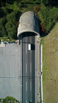 bird's eye drone view of truck passing through tunnel