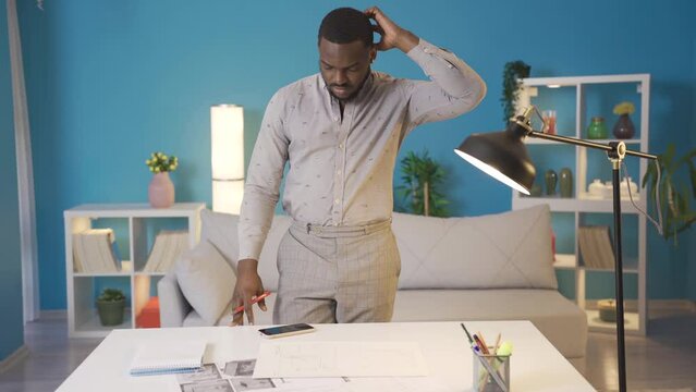 African man working on project at his home.
Black man working on project at home. Home office carrying out work.
