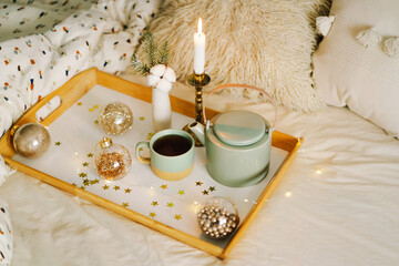 Hot tea, candle, Christmas golden balls and decorations. Christmas holiday mood in home. Winter concept.