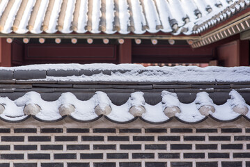 Korean traditional roof which has unique colors and pattern. White snow
