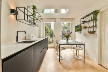a kitchen and dining area in a house with white walls, hardwood flooring and skylights on the...