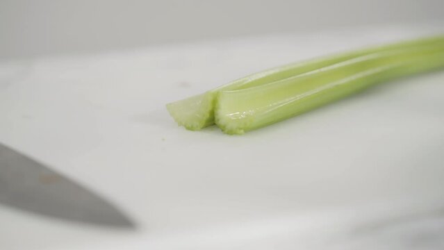 Time lapse. Curring vegetables on a white cutting board to cook vegetarian white bean soup.