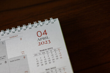 Top view shot of a 2023 calendar, "April page". Selective focus shot of a calendar, focused on "04, April, 2023".