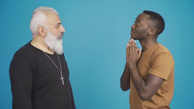 African muslim man and christian man inform each other about their religion and friendly smiling at camera.