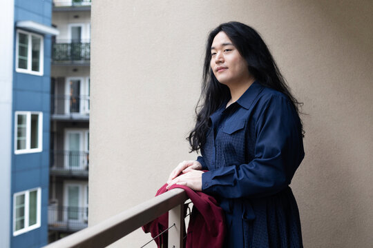Asian American trans woman standing outside.