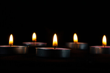 Candles of peace with dark bg and yellow flame on the dark.