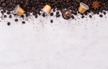 Dark roasted coffee beans setup on white concrete background with copy space.