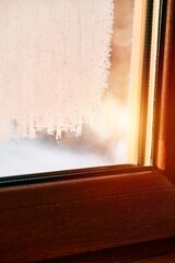 Frozen condensation on the interior window glass. Iced steam and dew on the glass during winter.