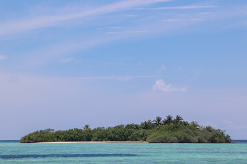 Island with a white sandy beach and blue clear sky 