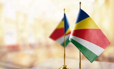 Small flags of the Seychelles on an abstract blurry background