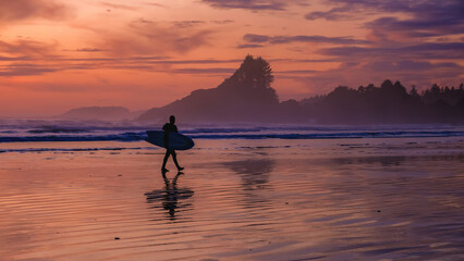 Tofino Vancouver Island Pacific rim coast, surfers with surfboard during sunset at the beach,...