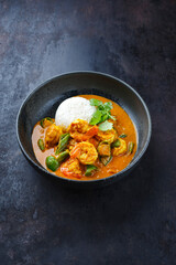 Traditional Thai kaeng phet red curry with chili and basmati rice served as close-up in a Nordic design bowl
