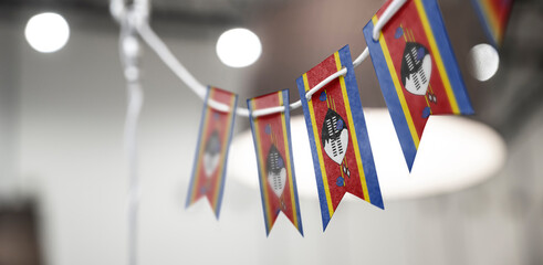 A garland of Swaziland national flags on an abstract blurred background