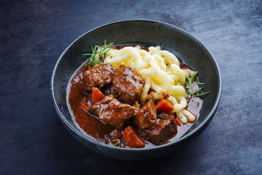Traditionelles ungarisches geschmortes Hirschgulasch mit Gem&uuml;se und Sp&auml;tzle in w&uuml;rziger Sauce serviert als close-up in einer Nordic Design Schale mit Textfreiraum