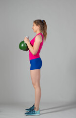 Training with kettlebells, a young athlete performs exercises with kettlebells, kettlebell lifting for the tone of the whole body