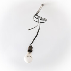 A temporary light bulb on a wire during repair close-up.