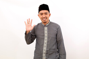 Happy asian muslim man standing while showing five fingers. Isolated on white background