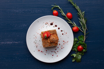 meat dish decorated with tomatoes and herbs