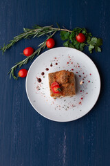 meat dish decorated with tomatoes and herbs