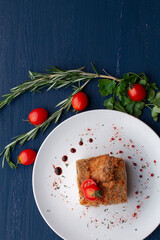 meat dish decorated with tomatoes and herbs