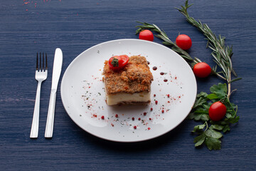 meat dish decorated with tomatoes and herbs