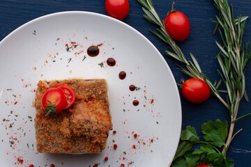meat dish decorated with tomatoes and herbs