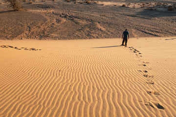 A man walking on a sand dune at North Horr Sand Dune in Marsabit County, Kenya