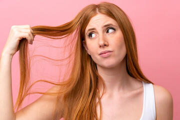 Obraz premium Young redhead woman isolated on pink background with tangled hair. Close up portrait