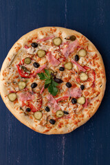 Delicious pizza with olives and sausages on wooden table