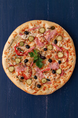 Delicious pizza with olives and sausages on wooden table