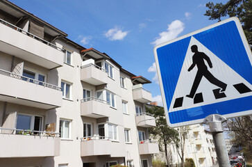 Close-up of crosswalk sign outside multi-family houses.