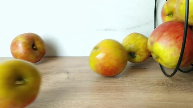 Ripe apples fall out of the basket. Slow motion
