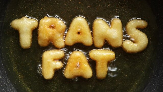 word TRANS FAT made from french fries in boiling oil,health food concept, Top view 