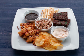 Beer snacks on the wooden table. Nuts, chips, pretzels.
