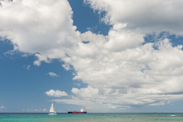 Coastline in Barbados with Caribbean ocean, Clear Blue Sky and Giant Ships in Background.