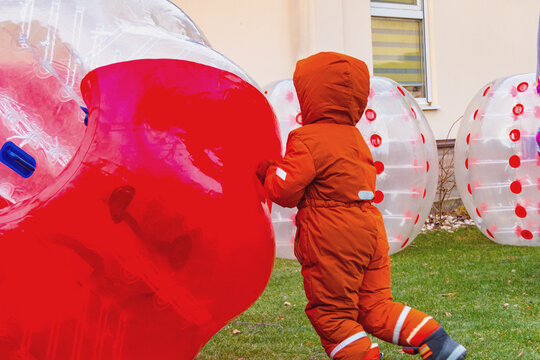 A Child Plays With A Zorb, A Large Inflatable Ball