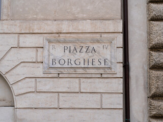 Roma, Italy. View of a Road name sign on a facade of a house. Piazza Borghese a very famous square in the city of Rome