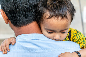 Asian refugee with his sick child at a border