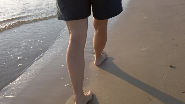 Woman walking barefoot at the seaside, 4k close-up POV footage following