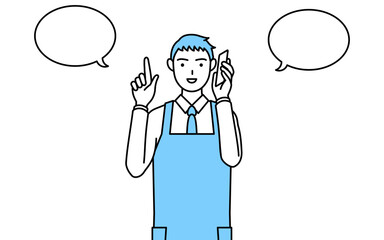 電話をしながら指さしをするエプロンを着た男性