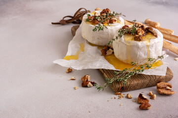 Obraz na płótnie Canvas Brie or camembert cheese with thyme, nuts, honey and grissini breadstick
