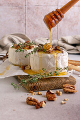 Brie or camembert cheese with thyme, nuts, honey and grissini breadstick