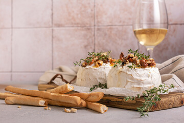 Brie or camembert cheese with thyme, nuts, honey, grissini and glass of white wine